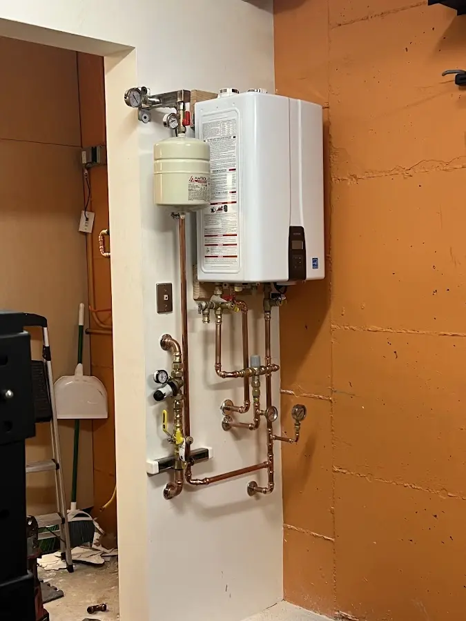 Plumbing technician inspecting water heater connections in Bel Air